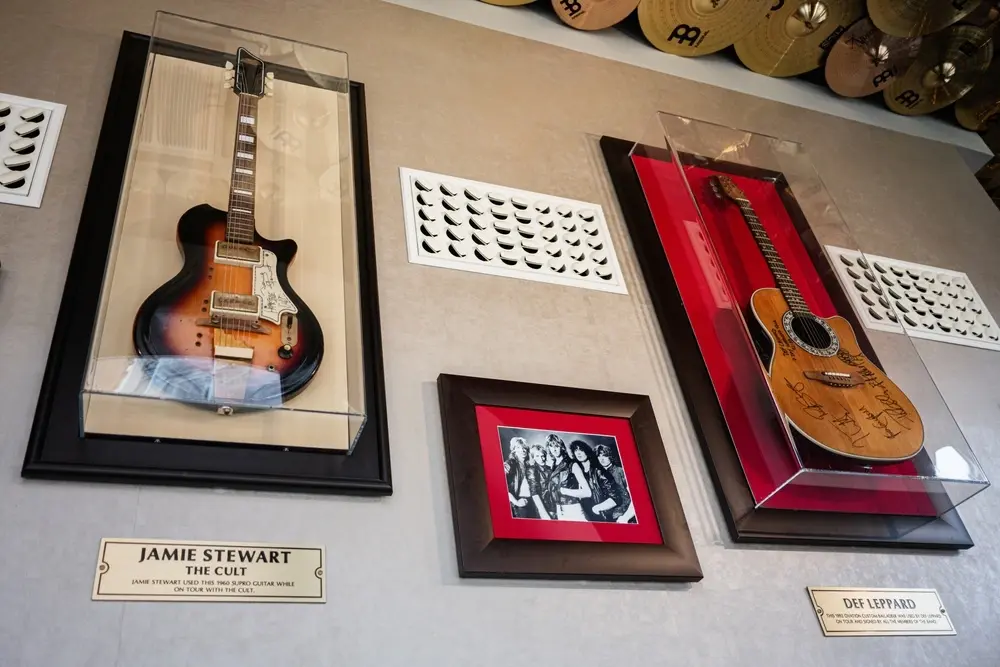framed signed guitars hanging on wall